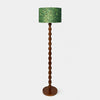 Full view of sculptural wood floor lamp with patterned fabric drum shade
