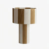 Apricot and white striped woven shade table lamp on a white background