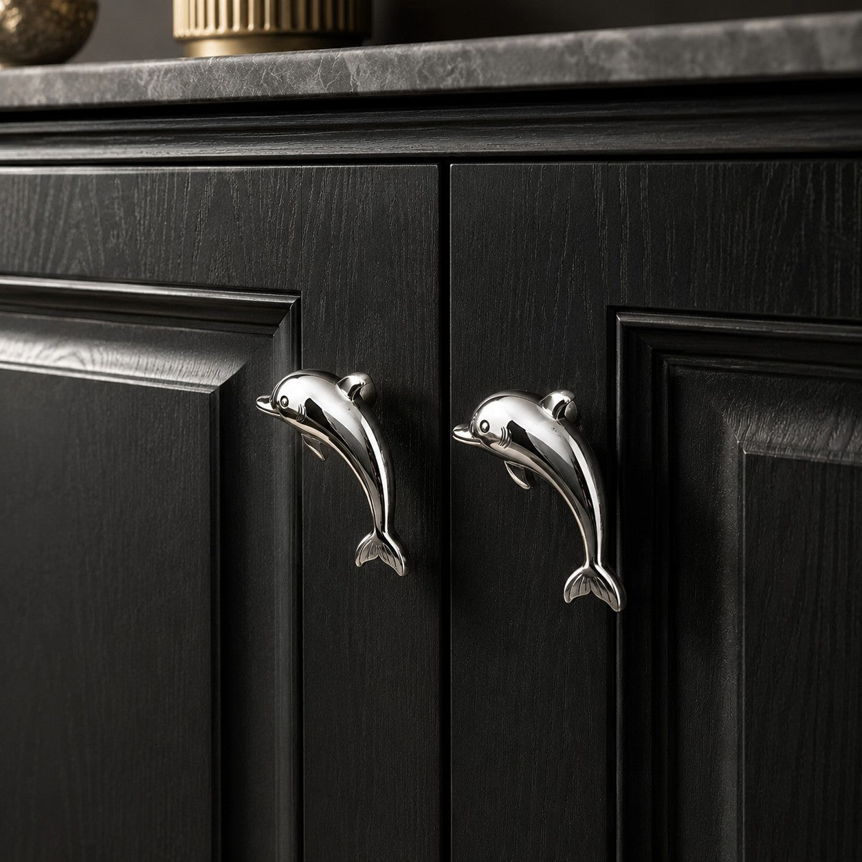 Chrome dolphin handles on black cabinet doors