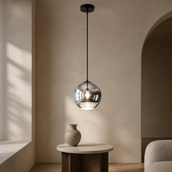 Style A Luma mirrored globe pendant above a small table