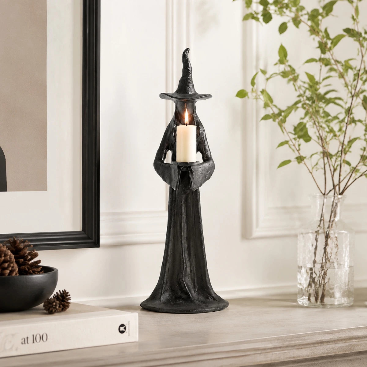 Single Candle Aura candlestick with lit candle on shelf