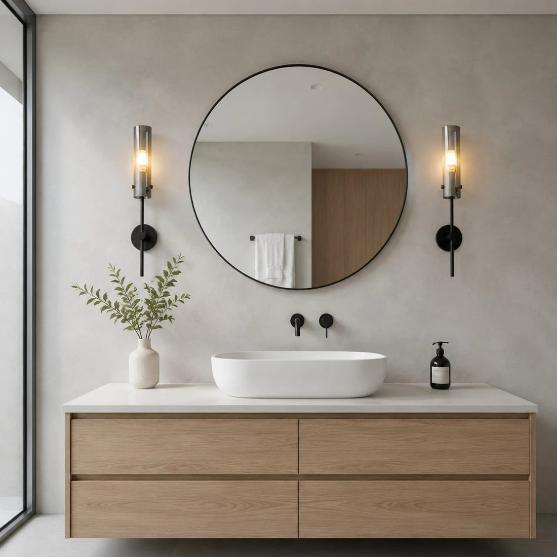 Black copper alabaster wall sconces installed beside a round bathroom mirror