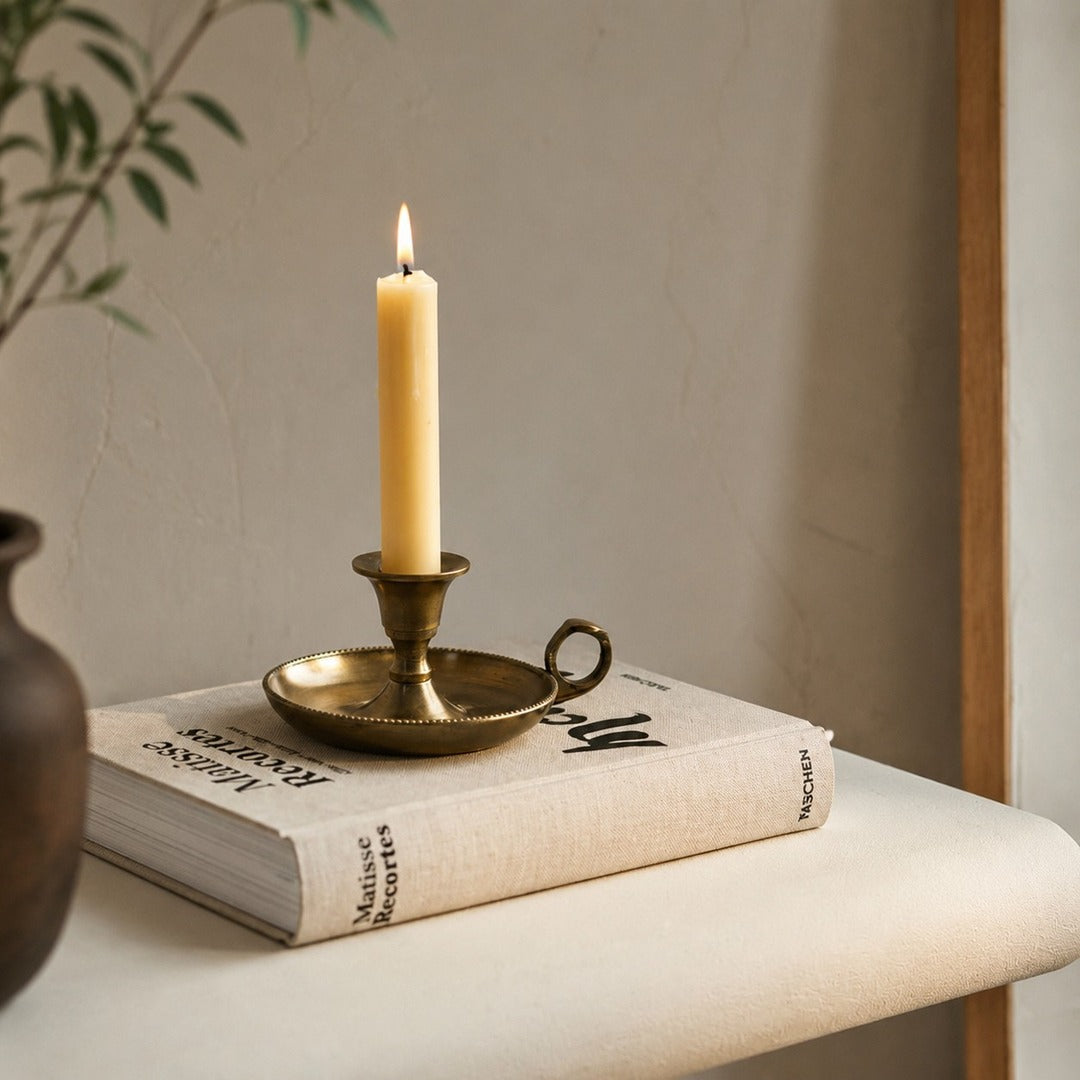 Aura candlestick on book with lit candle