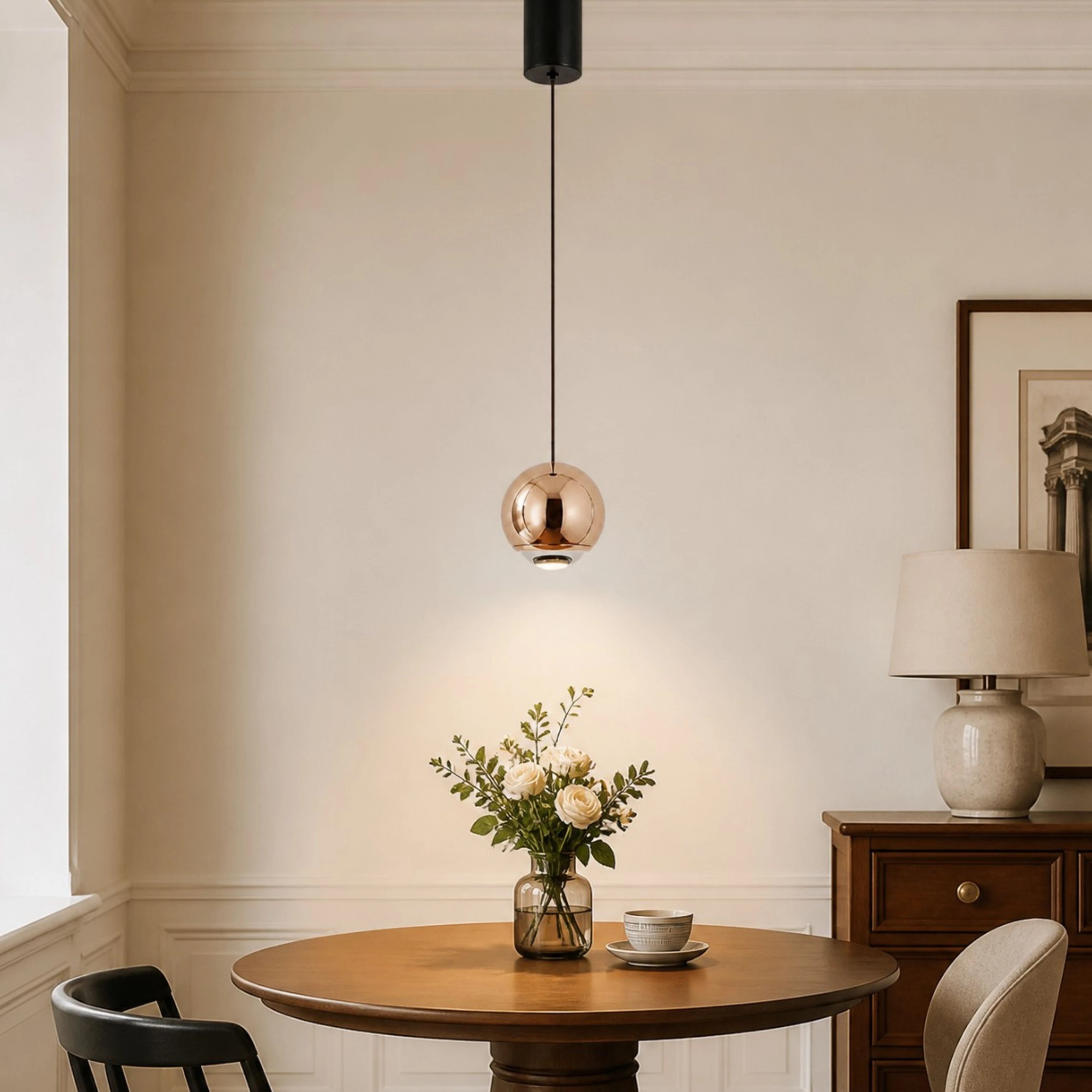 Rose Gold mirrored orb pendant above a dining table
