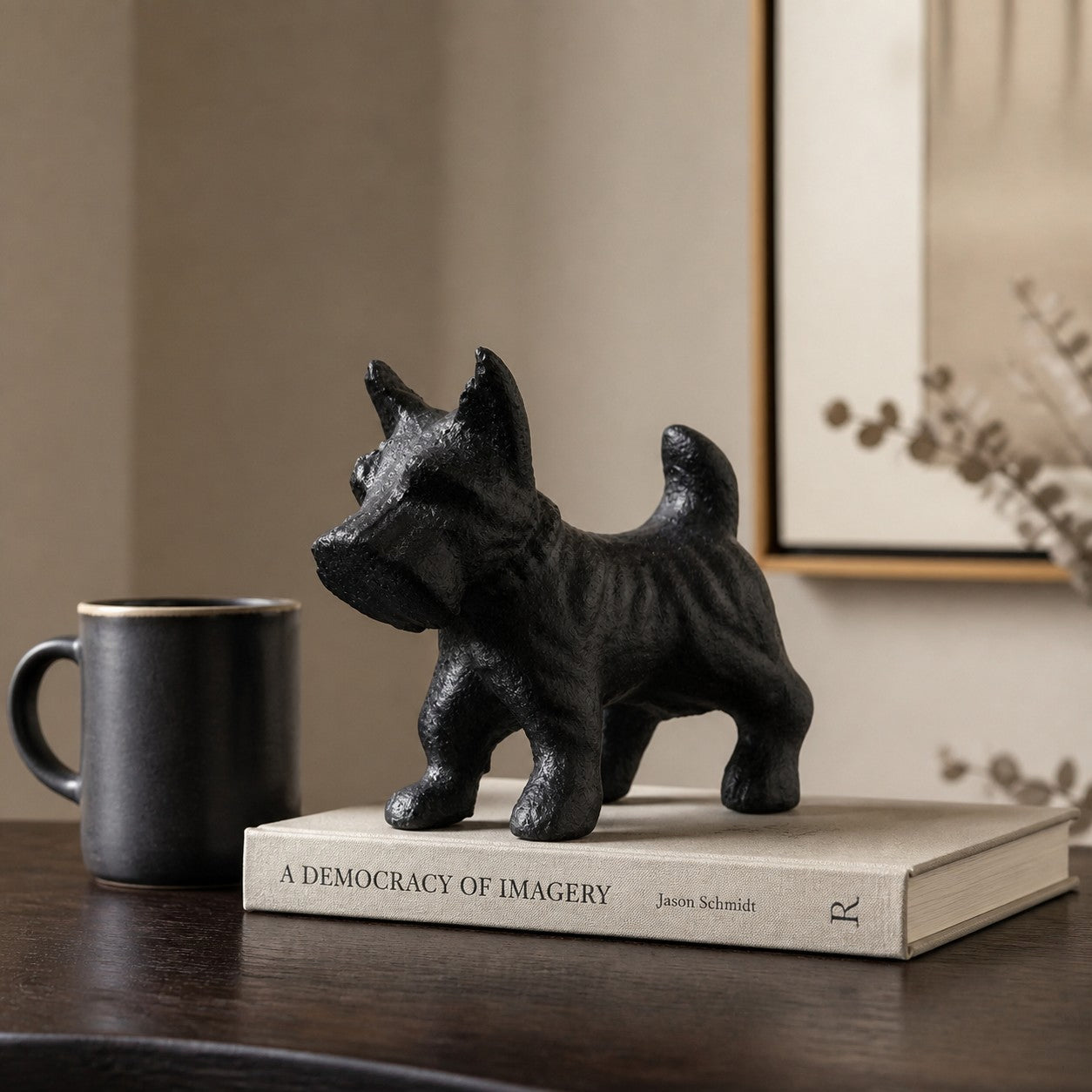 Miniature cast iron Schnauzer displayed beside books and a cup