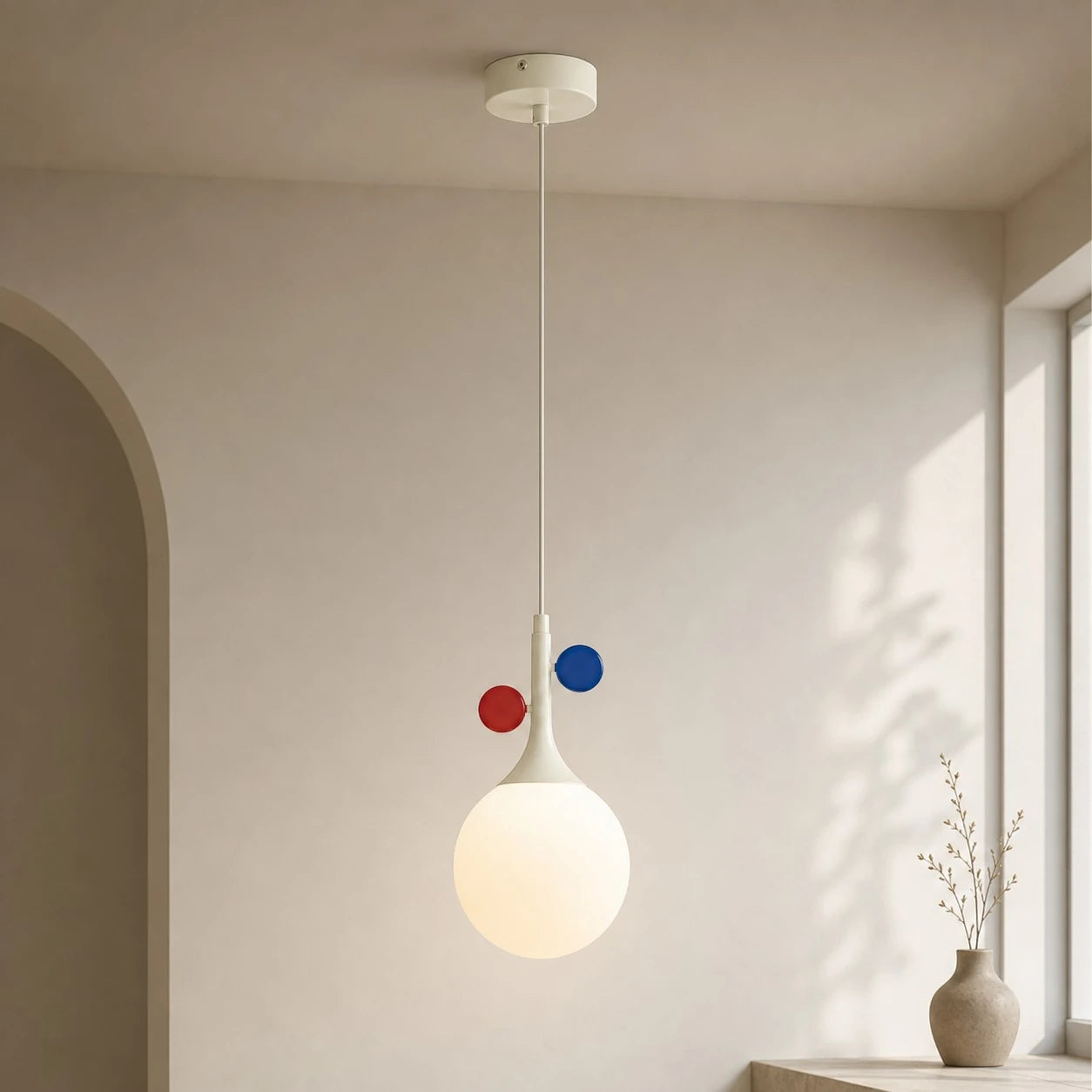Cream orbit-disc pendant beside a sunlit window