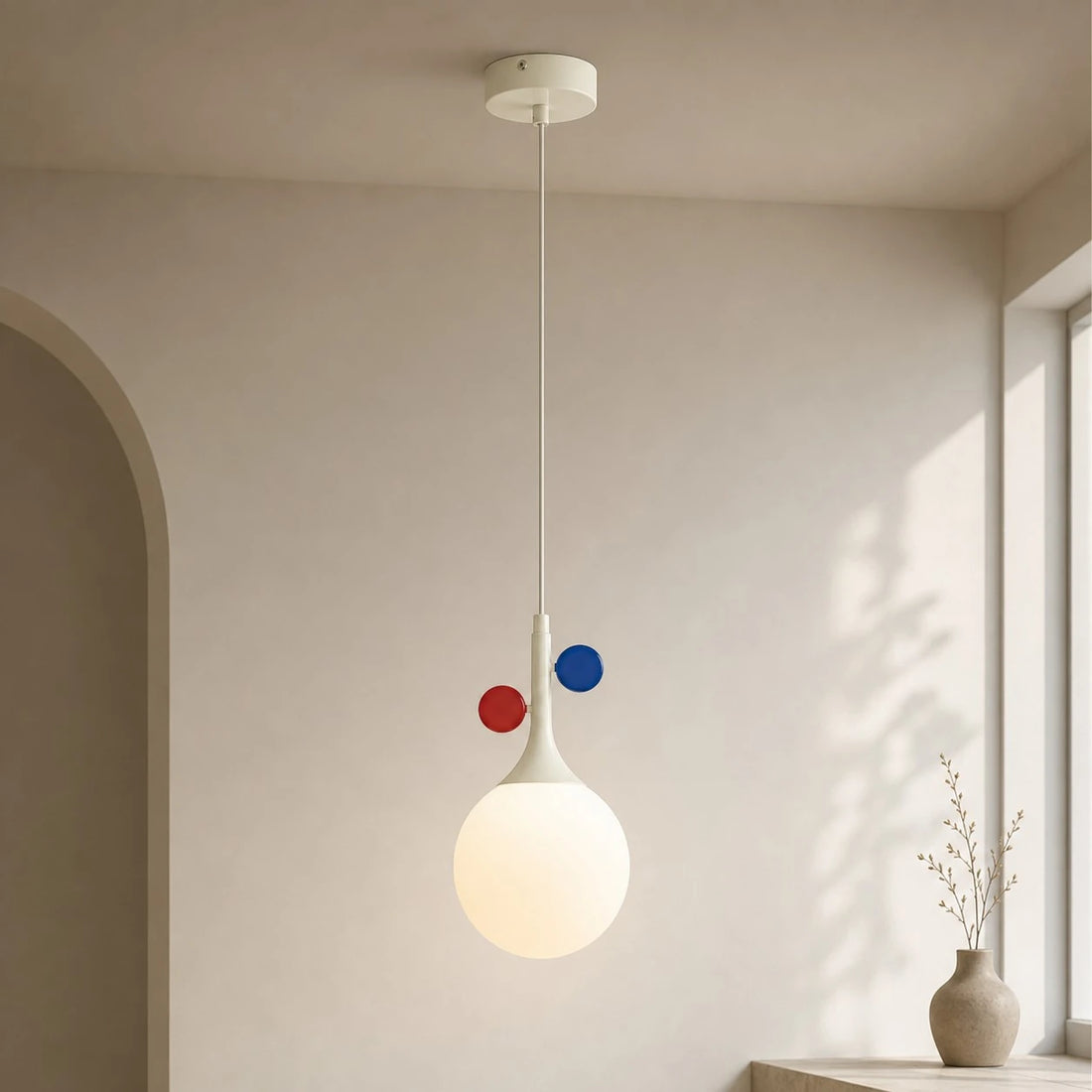 Cream orbit-disc pendant beside a sunlit window