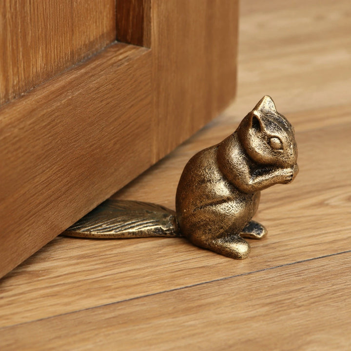 Bronze Guardian door stopper under a wooden door