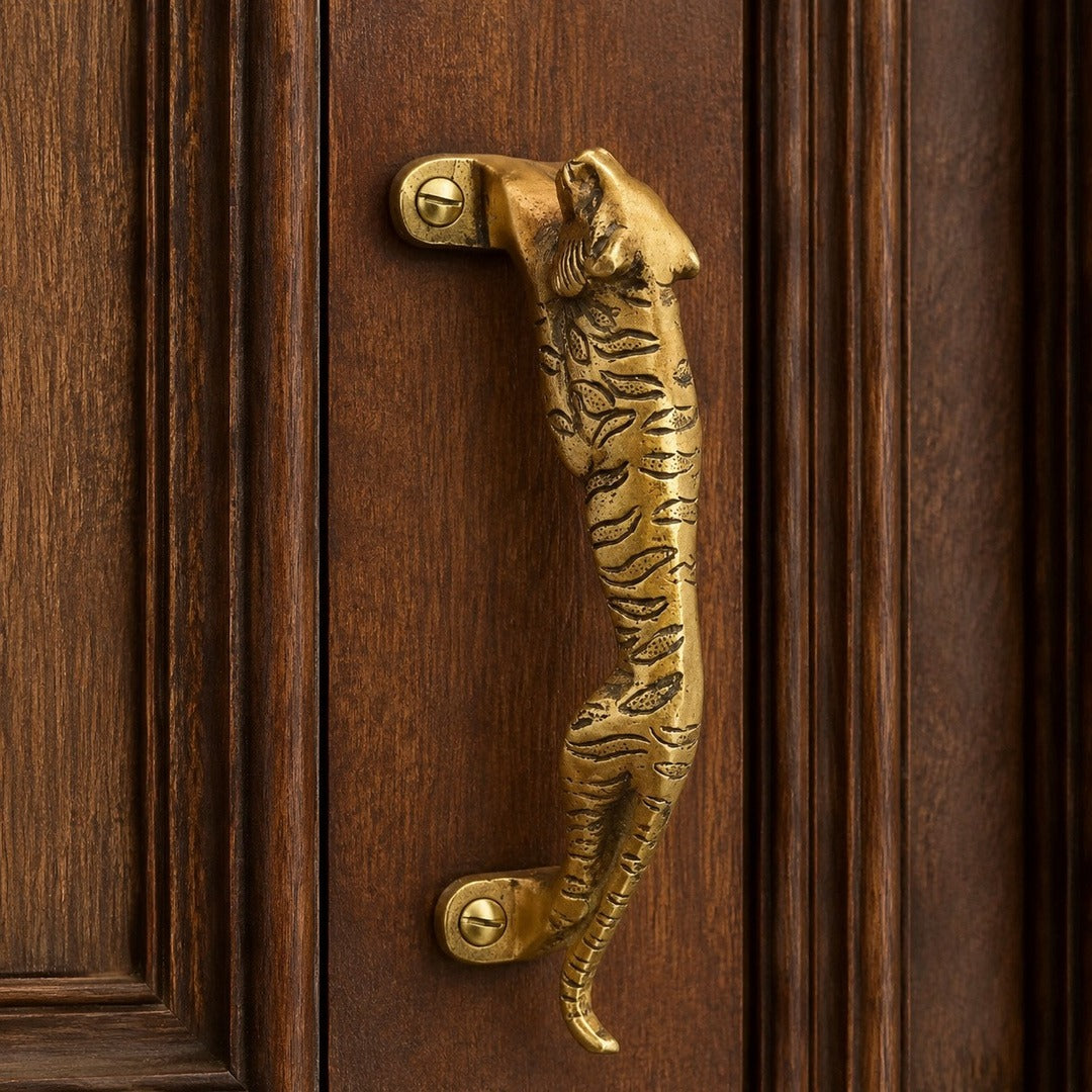 Leopard A brass cabinet handle close view on a dark door