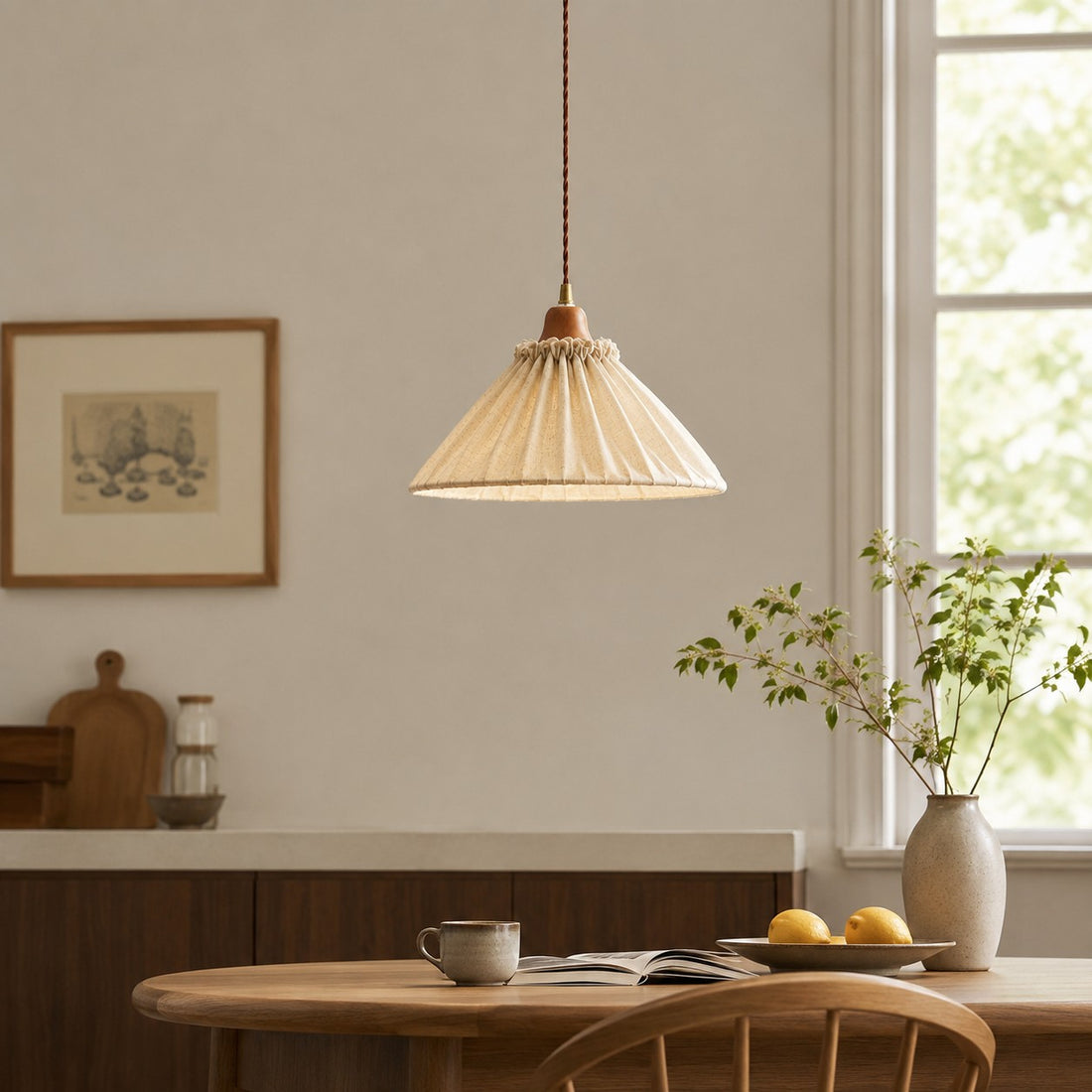 Natural linen pendant light above a quiet reading corner with wood furniture