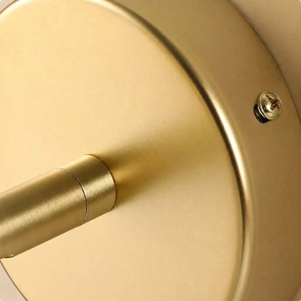 Close-up of the gold round wall plate and fixing screws