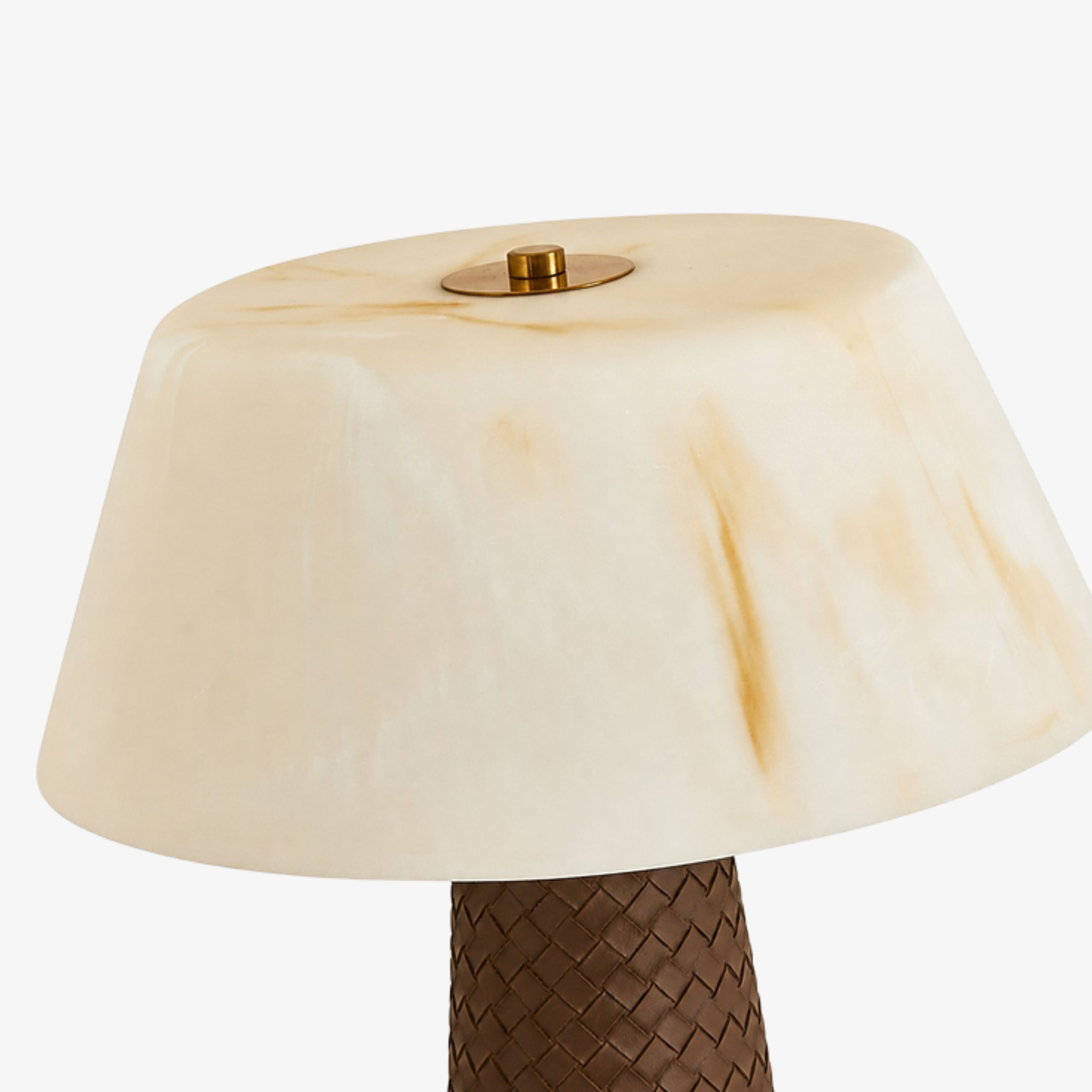 Close view of the cream faux marble shade and brass finial