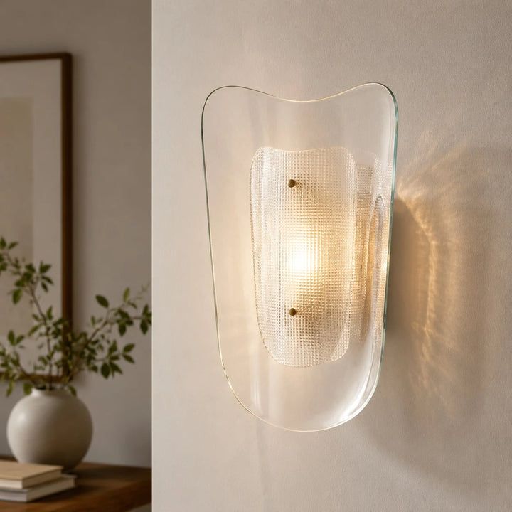Clear glass wall sconce installed in a styled interior