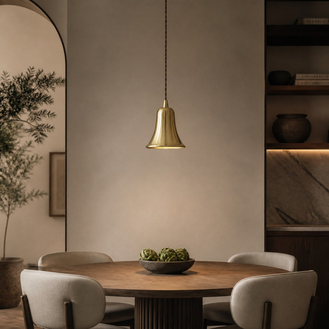 Bell-shaped natural brass pendant light in a warm dining room