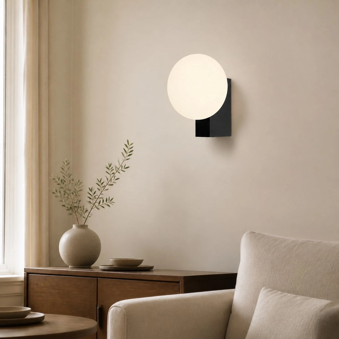 Black folded globe wall sconce in a neutral lounge