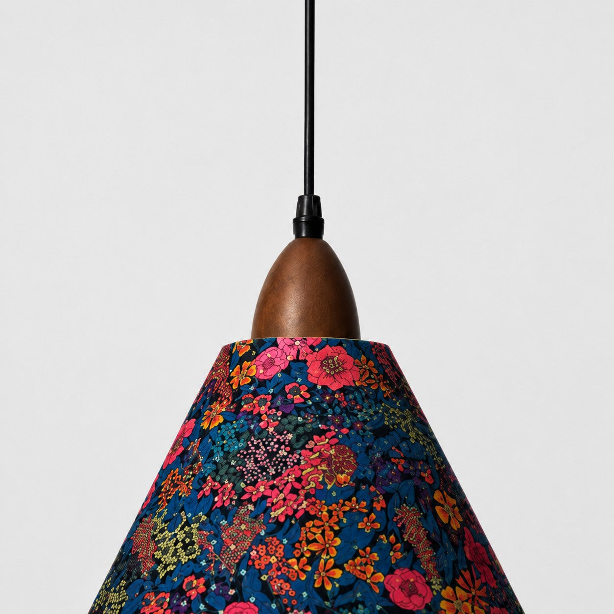 Close-up of walnut-tone wood holder and dark botanical Liberty fabric