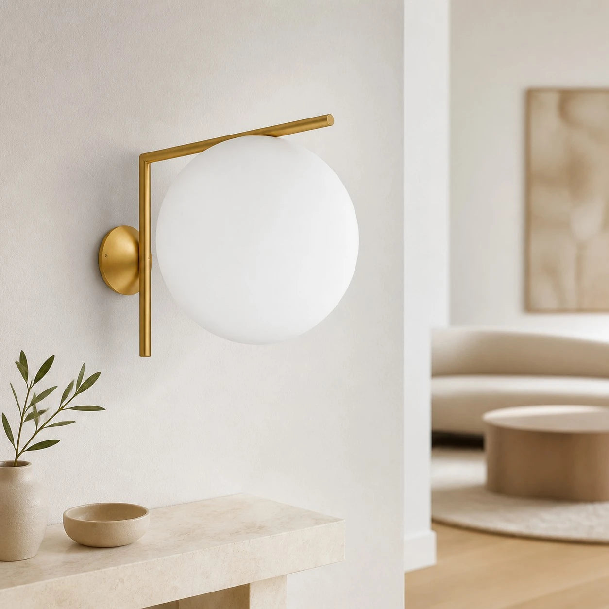 Gold offset globe wall sconce in a bright entryway