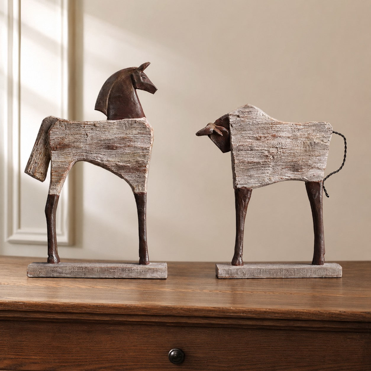 Equora horse and bull sculptures on a wood console