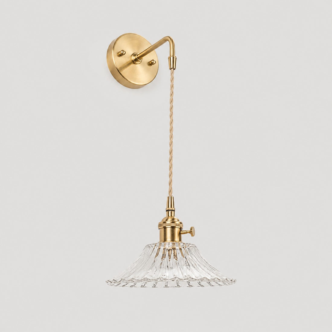 Clear shallow glass wall light with brass arm, W shade 6 cm high and 18 cm diameter