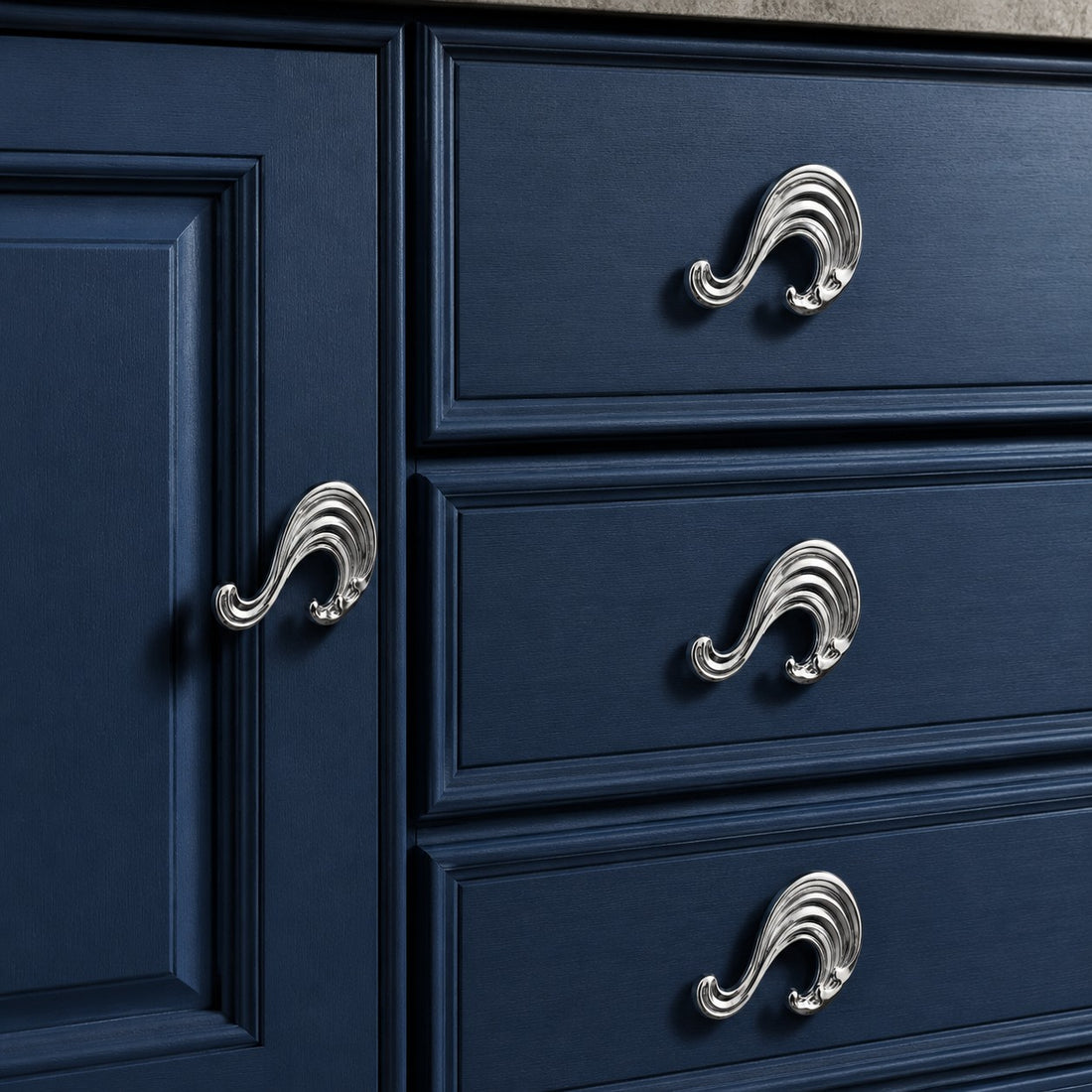 Chrome wave handles on blue cabinet drawers