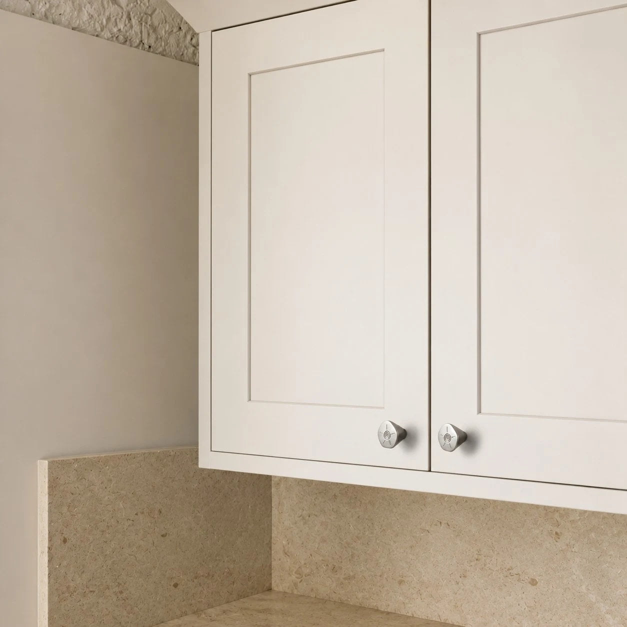 Titanium silver knobs on white cabinet doors
