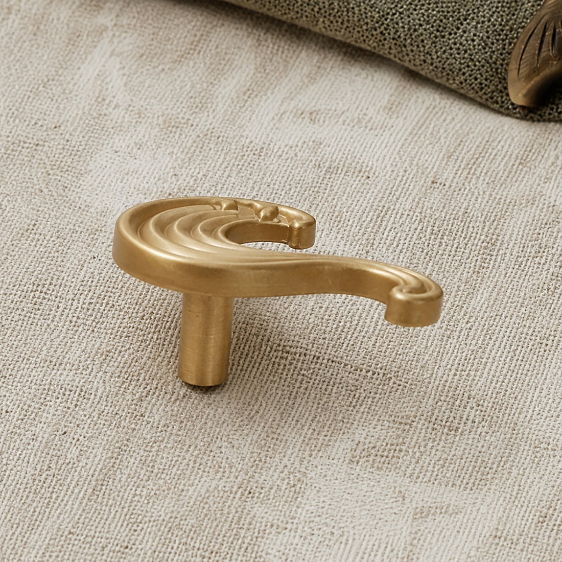 Side profile of the Totem wave cabinet handle in natural brass