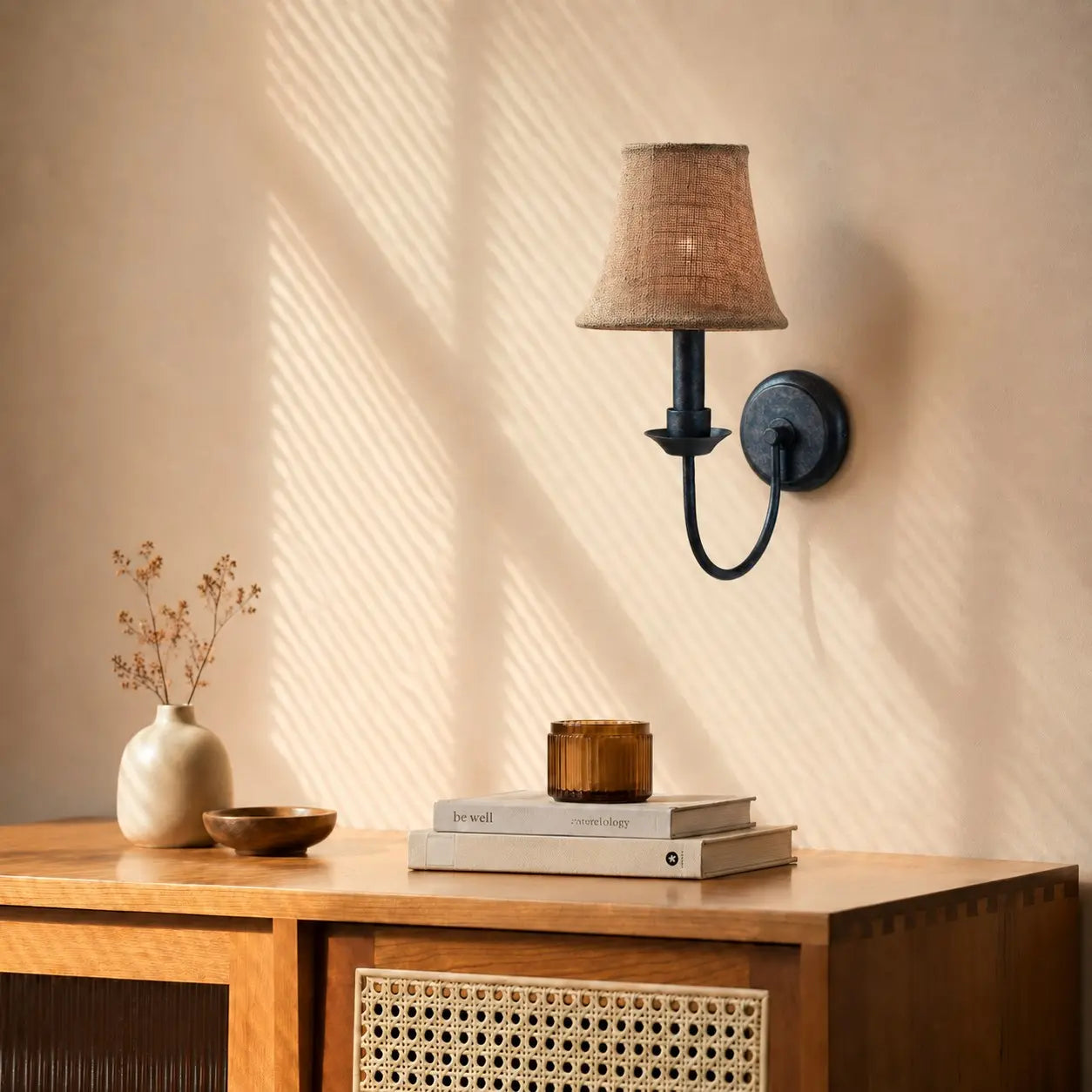 Fabric wall sconce above a warm wood console