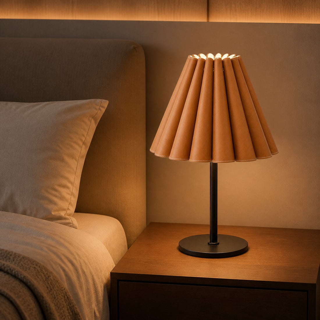 Caramel brown pleated leather table lamp beside a bed