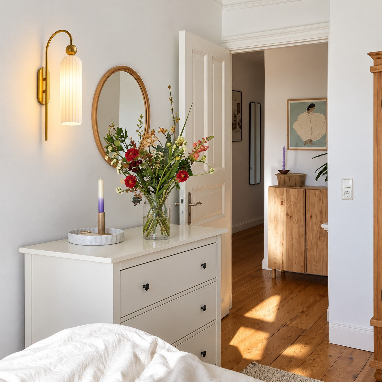Aura milk glass wall sconce beside a bedroom dresser