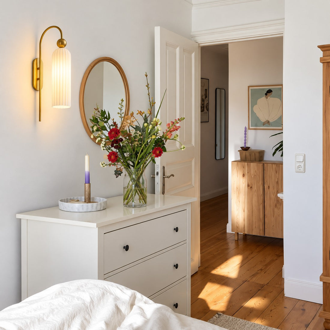 Aura milk glass wall sconce beside a bedroom dresser