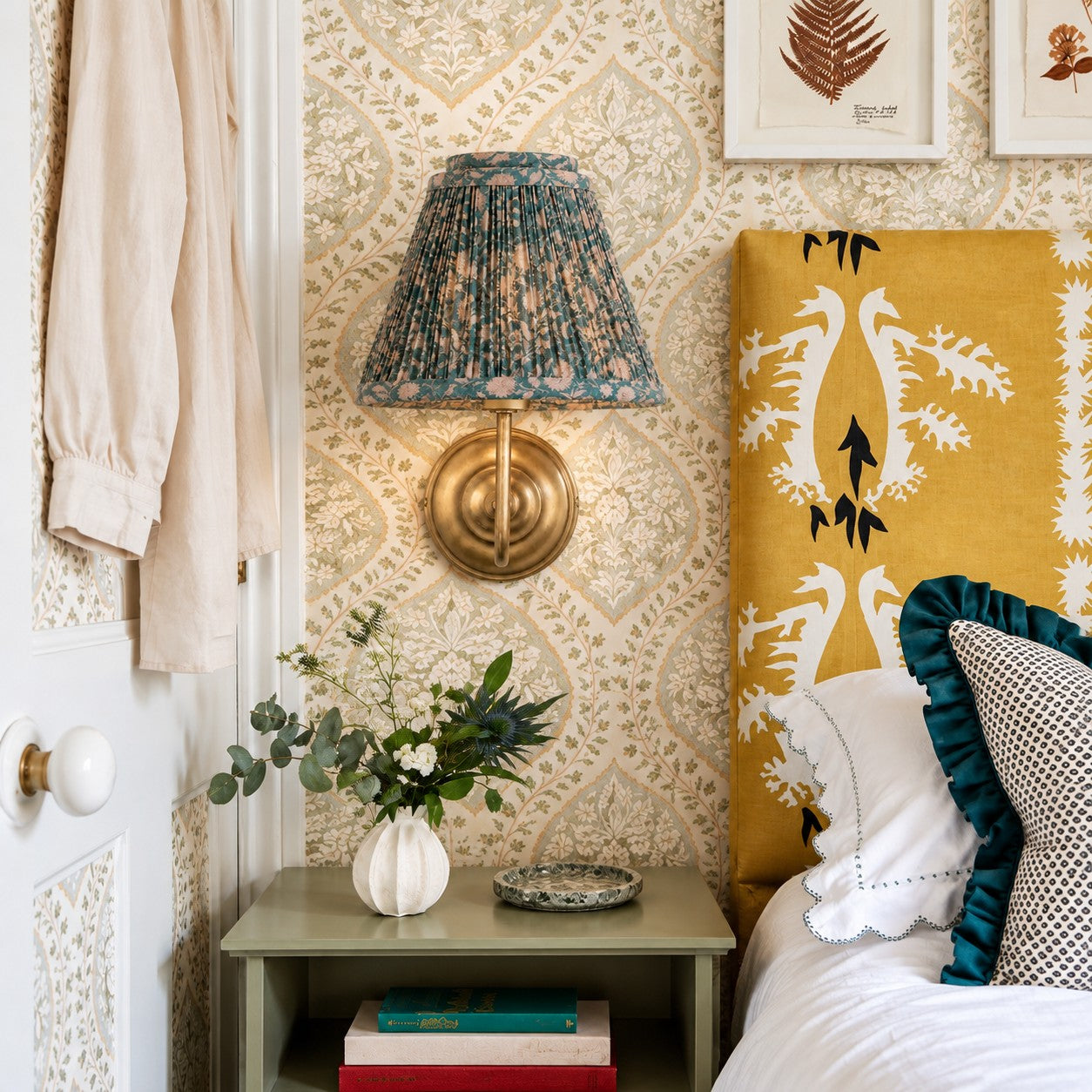 Avelora wall sconce styled on floral wallpaper by a bed