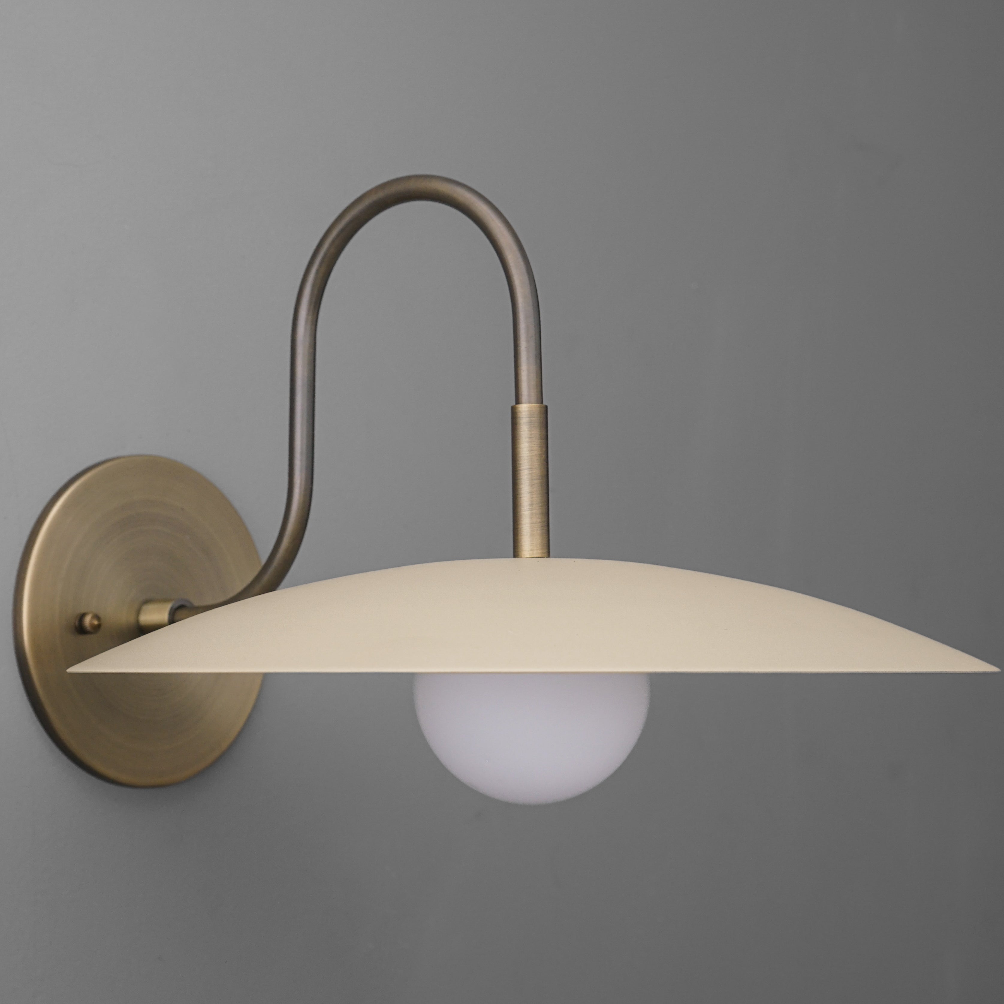 Curva Metal Modern Wall Sconce - Antique Brass Arm with Cream Disc Shade