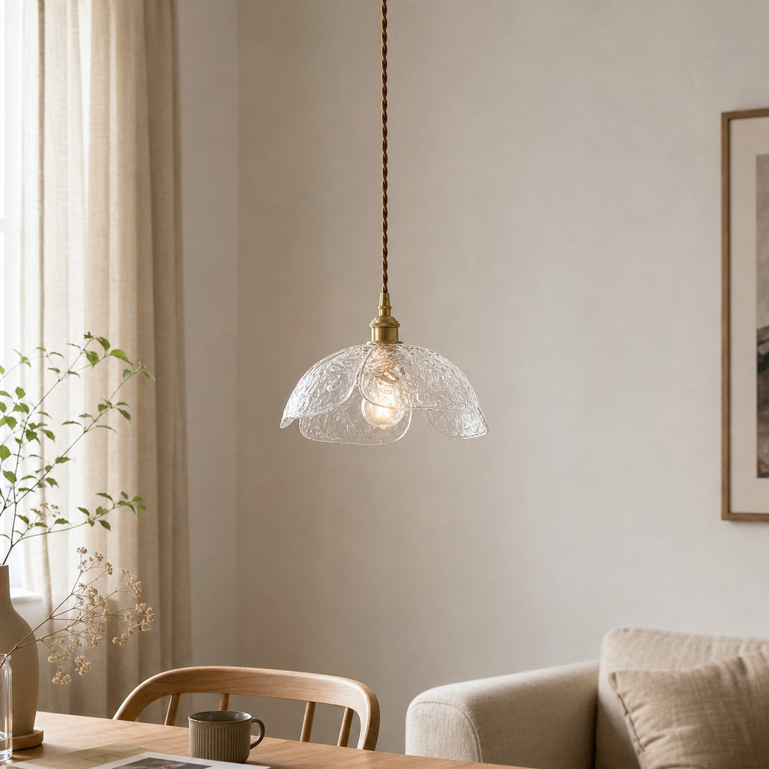 Clear glass flower pendant above a light dining nook