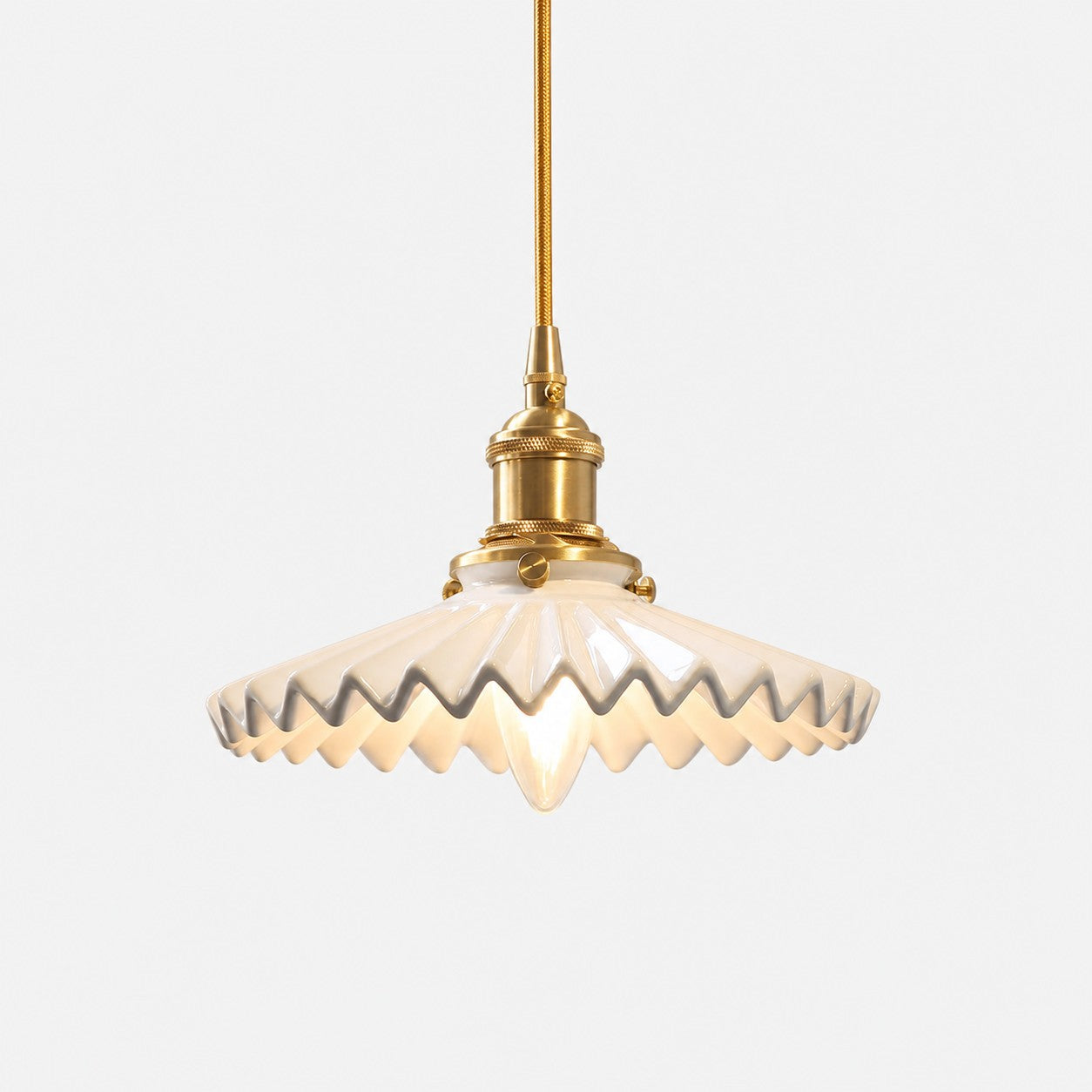 White pleated ceramic pendant light with brass-finish base