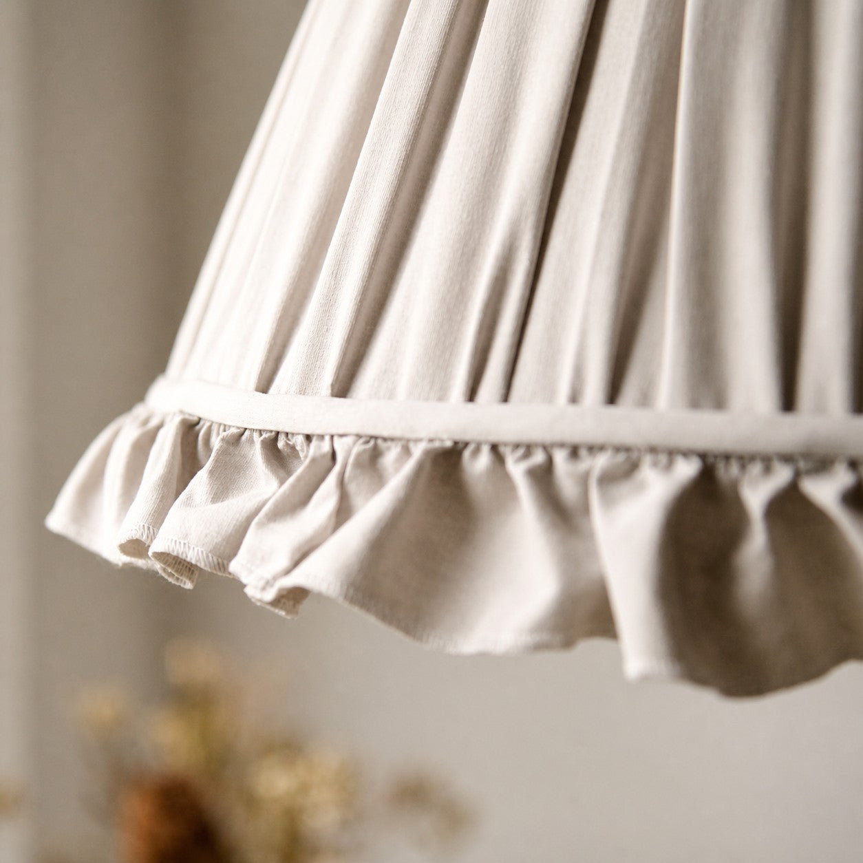 Close view of the pleated fabric shade and scalloped trim