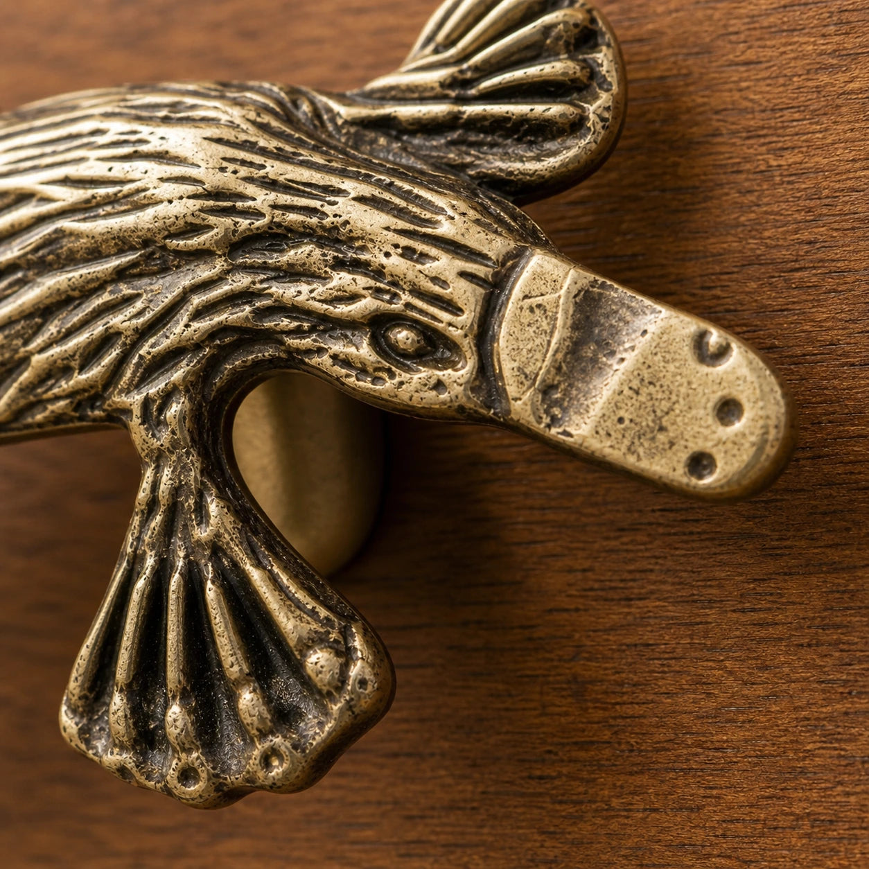 Macro detail of webbed foot and lower copper relief on Totem handle