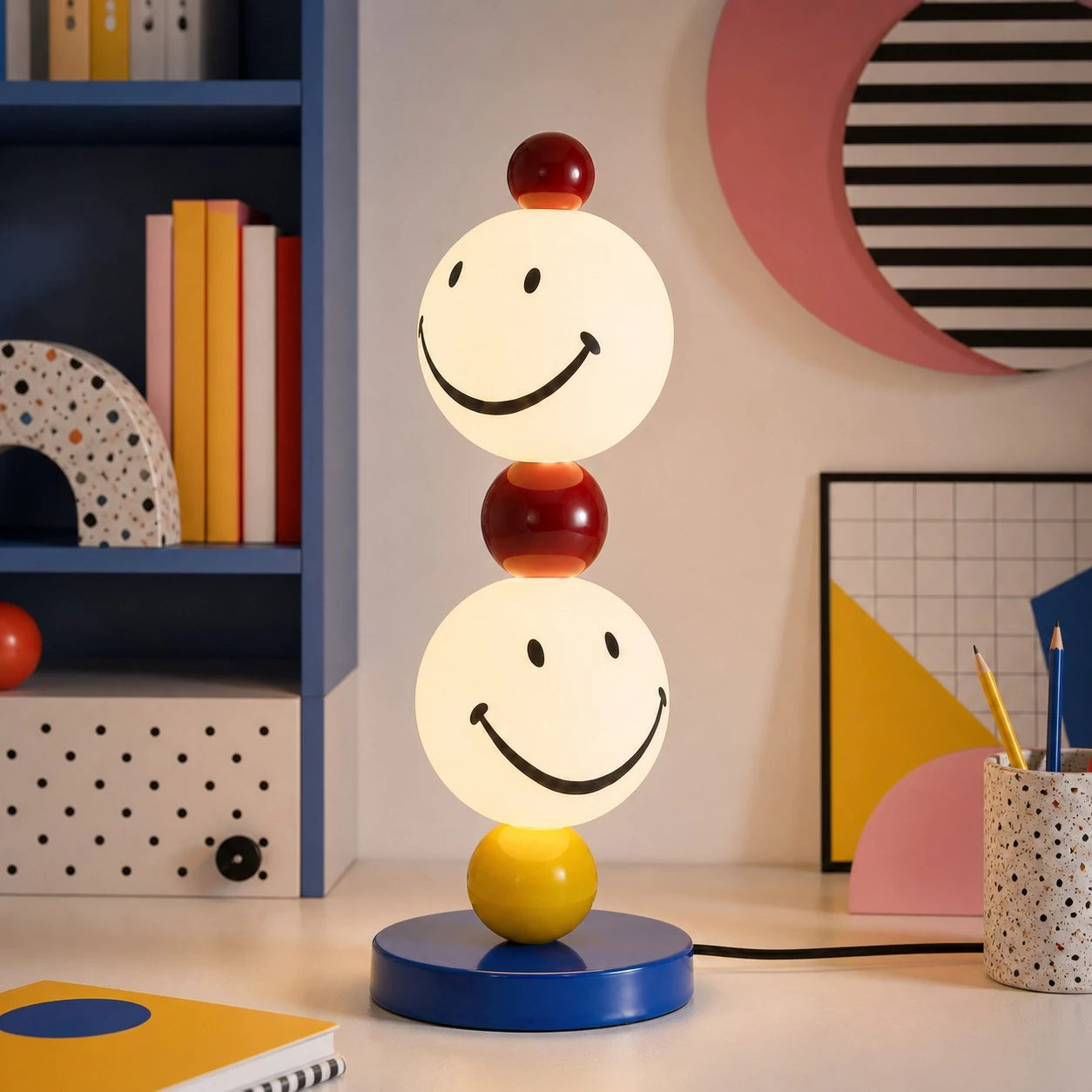 Smiley stack table lamp beside a colorful shelf