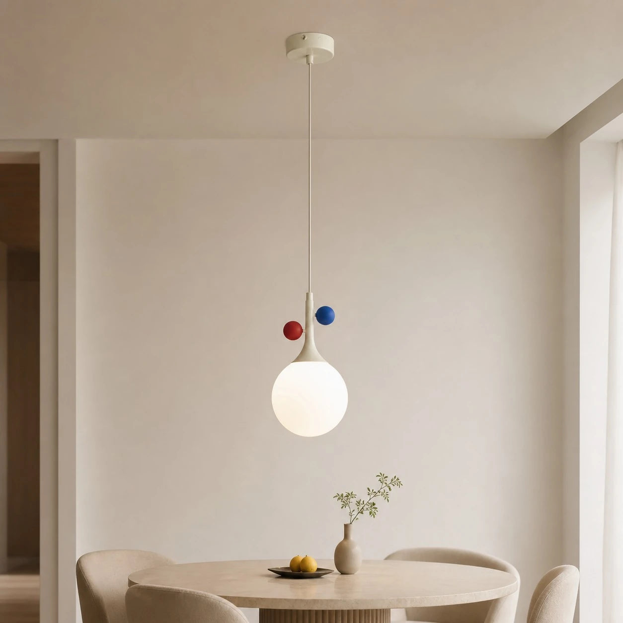 Cream orbit-disc pendant above a wide dining-room setting