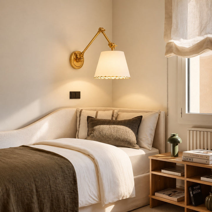 White Foldray sconce styled beside a boucle daybed