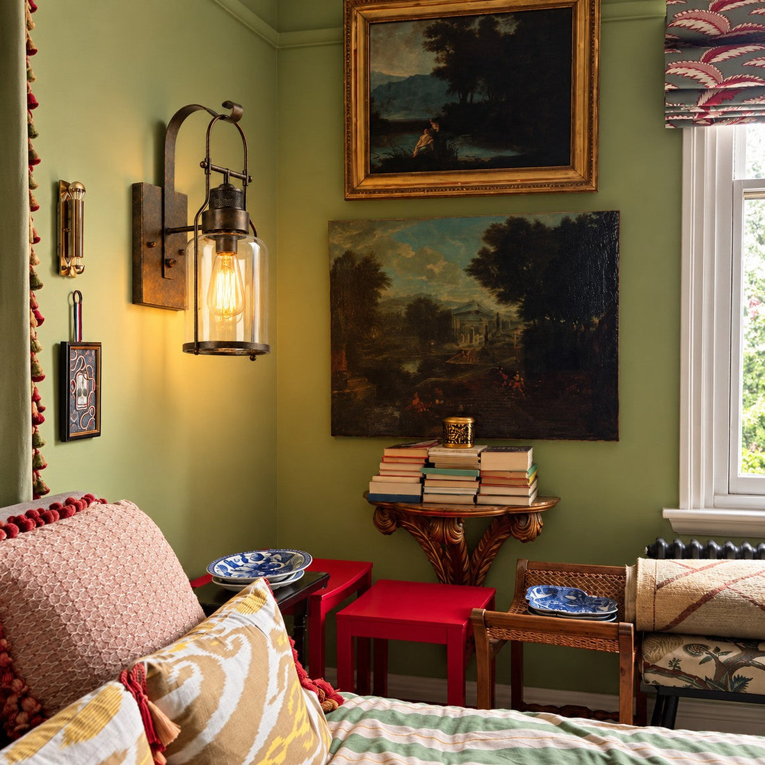 Wall sconce styled in a green room with paintings